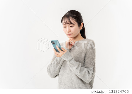 女性　カジュアル　スマホ　悩む 131224706
