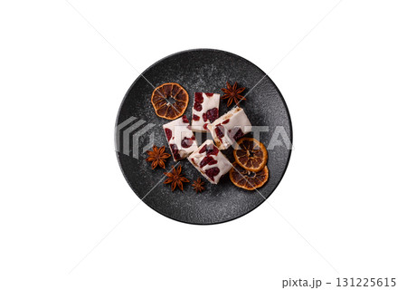 Nougat or white caramel with hazelnuts and pistachios and citrus pieces. White nougat with nuts 131225615