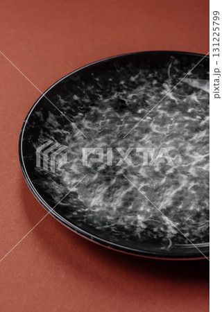 Empty round black plate for food, kitchen utensils on dining table. Empty plate 131225799