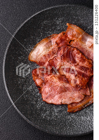 Cooked fried crispy bacon as an ingredient of a delicious English breakfast. Pieces of fried bacon 131226400