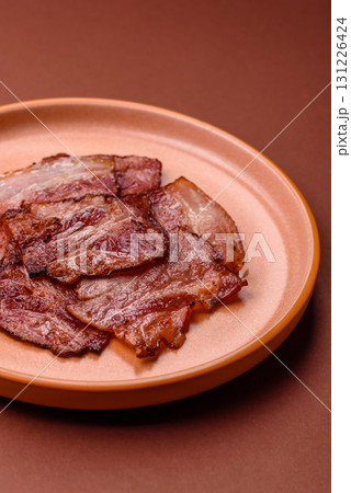 Cooked fried crispy bacon as an ingredient of a delicious English breakfast. Pieces of fried bacon Cooked fried crispy bacon as an ingredient of a delicious English breakfast. Pieces of fried bacon 131226424