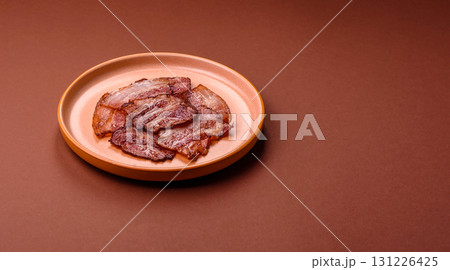 Cooked fried crispy bacon as an ingredient of a delicious English breakfast. Pieces of fried bacon 131226425