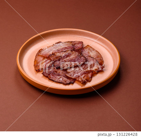 Cooked fried crispy bacon as an ingredient of a delicious English breakfast. Pieces of fried bacon Cooked fried crispy bacon as an ingredient of a delicious English breakfast. Pieces of fried bacon 131226428