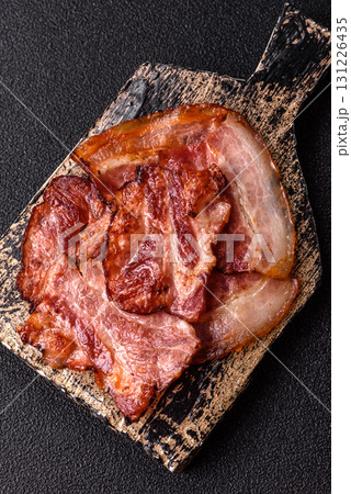 Cooked fried crispy bacon as an ingredient of a delicious English breakfast. Pieces of fried bacon 131226435