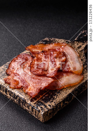Cooked fried crispy bacon as an ingredient of a delicious English breakfast. Pieces of fried bacon Cooked fried crispy bacon as an ingredient of a delicious English breakfast. Pieces of fried bacon 131226436