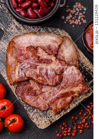 Cooked fried crispy bacon as an ingredient of a delicious English breakfast. Pieces of fried bacon 131226439