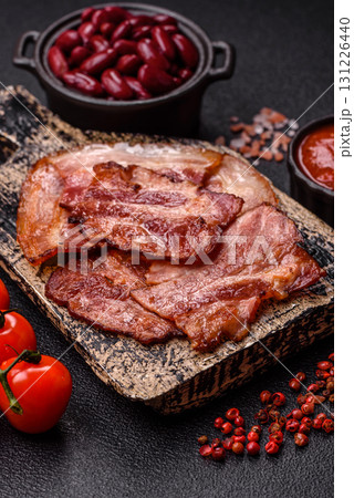 Cooked fried crispy bacon as an ingredient of a delicious English breakfast. Pieces of fried bacon 131226440