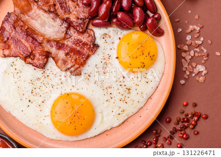 Fried egg, bacon and beans, a classic British breakfast with tomatoes. Egg, bacon and beans Fried egg, bacon and beans, a classic British breakfast with tomatoes. Egg, bacon and beans 131226471
