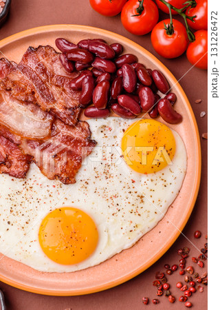 Fried egg, bacon and beans, a classic British breakfast with tomatoes. Egg, bacon and beans Fried egg, bacon and beans, a classic British breakfast with tomatoes. Egg, bacon and beans 131226472
