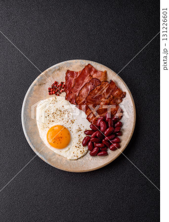 Fried egg, bacon and beans, a classic British breakfast with tomatoes. Egg, bacon and beans Fried egg, bacon and beans, a classic British breakfast with tomatoes. Egg, bacon and beans 131226601