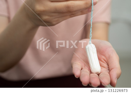 Asian woman holding cotton tampons for hygiene menstrual period cycle protection. Asian woman holding cotton tampons for hygiene menstrual period cycle protection. 131226973
