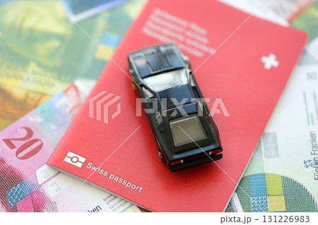 Swiss franc banknotes and toy car with passport. The current francs money bills and car with pass 131226983