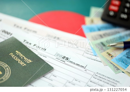 Bangladeshi taka money bills lies on table with pen, calculator, passport and tax forms Bangladeshi taka money bills lies on table with pen, calculator, passport and tax forms 131227054