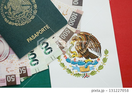 Mexican pesos money bills in big amount and passport lies on Mexico flag close up Mexican pesos money bills in big amount and passport lies on Mexico flag close up 131227058