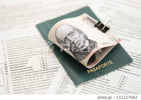 Mexican pesos money bills in big amount lies on table with passport and tax forms close up 131227062