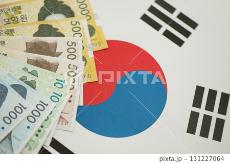 South Korean won money bills in big amount lies on South Korea flag close up South Korean won money bills in big amount lies on South Korea flag close up 131227064