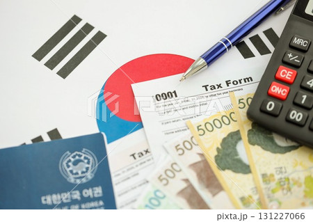 South Korean won money bills lies on table with pen, calculator, passport and tax forms 131227066