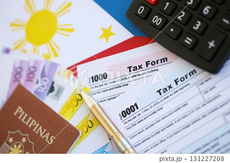 Philippines peso money bills and calculator with tax form on flag. Taxation and accounting concept 131227208
