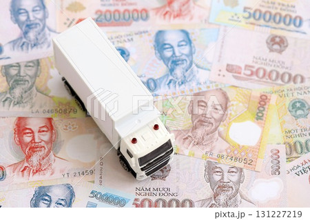 Vietnamese dong currency money bills and toy delivery truck. The concept of delivery and logistics 131227219