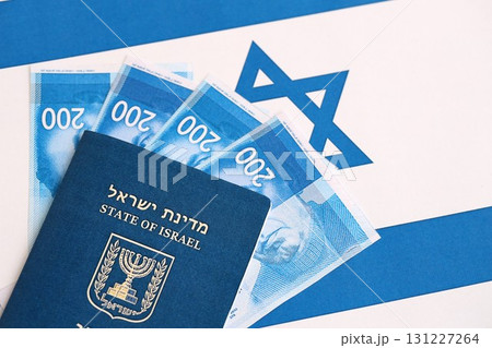 Israel New Shekels banknotes and passport on flag. The current Israel money bills and pass 131227264