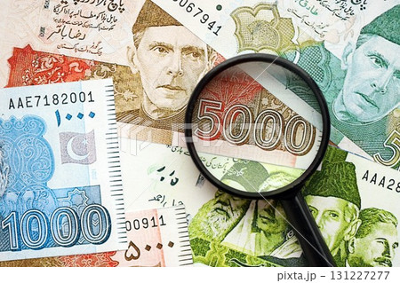 Pakistan rupees banknotes and magnifying glass. The current Pakistan money bills with loupe 131227277