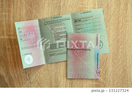 German temporary Permanent resident card lies on wooden table. Fiktionsbescheinigung German temporary Permanent resident card lies on wooden table. Fiktionsbescheinigung 131227324
