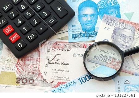 Nigerian naira currency money bills and calculator with magnifying glass. The concept of taxation and money count 131227361