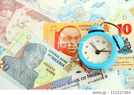 Nigerian naira currency money bills and alarm clock. The concept of time management and income Nigerian naira currency money bills and alarm clock. The concept of time management and income 131227364