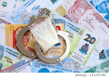 Nigerian naira currency money bills and cocaine pack with handcuffs. The concept of drug crimes Nigerian naira currency money bills and cocaine pack with handcuffs. The concept of drug crimes 131227365