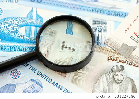 United Arab Emirates dirham currency money bills and magnifying glass. The concept of financial monitoring and taxation 131227386