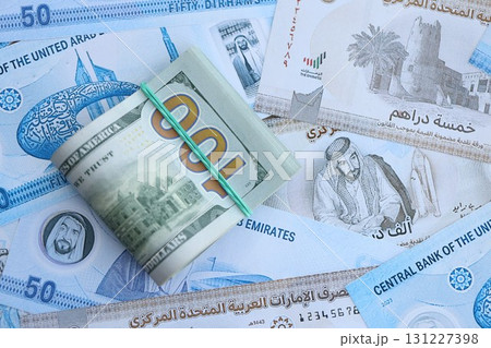 United Arab Emirates dirham currency money bills and bunch of us dollar banknotes. The concept of economics and currency exchange United Arab Emirates dirham currency money bills and bunch of us dollar banknotes. The concept of economics and currency exchange 131227398