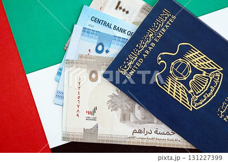 United Arab Emirates dirham currency money bills and passport lies on flag. The concept of travel and vacation 131227399