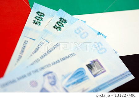 United Arab Emirates dirham currency money bills lies on flag. The concept of business and investment 131227400