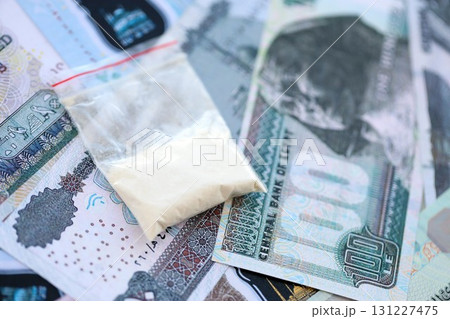 Egyptian pound currency money bills and cocaine pack. The concept of drug trafficking Egyptian pound currency money bills and cocaine pack. The concept of drug trafficking 131227475