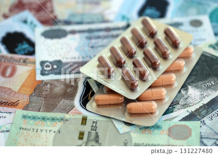 Egyptian pound currency money bills and medicine pills. The concept of medicine and pharmacy Egyptian pound currency money bills and medicine pills. The concept of medicine and pharmacy 131227480