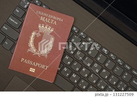 Malta passport lies on black laptop keyboard buttons background . Technologies in Europe 131227509