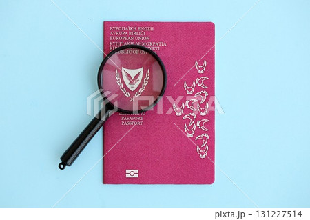 Kyprus passport and magnifying glass on light blue paper. Citizenship details and information Kyprus passport and magnifying glass on light blue paper. Citizenship details and information 131227514