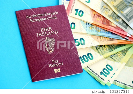 Ireland passport lies with euro money banknotes on blue background. Salary and pension in Europe 131227515
