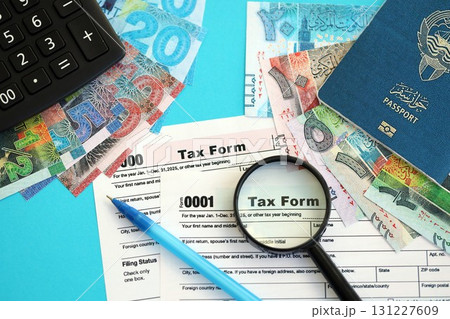 Kuwaiti dinar money bills and calculator with tax form on blue. Taxation and accounting concept 131227609