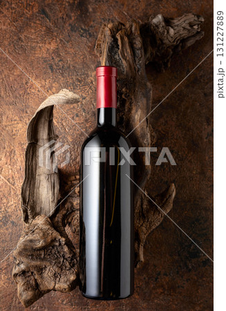 Bottle of red wine and old weathered snags. Bottle of red wine and old weathered snags. 131227889