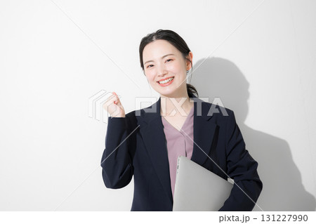 パソコン持ってスーツを着た立つ若いかわいい女性のビジネス上半身 ガッツポーズ パソコン持ってスーツを着た立つ若いかわいい女性のビジネス上半身 ガッツポーズ 131227990