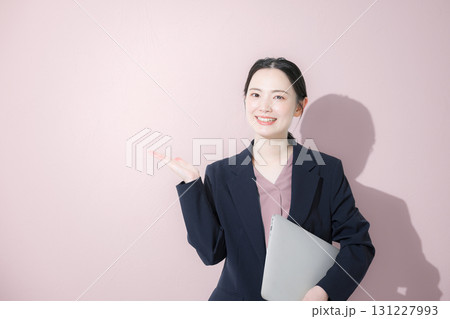 パソコン持ってスーツを着た立つ若いかわいい女性のビジネス上半身 パソコン持ってスーツを着た立つ若いかわいい女性のビジネス上半身 131227993