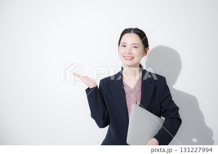 パソコン持ってスーツを着た立つ若いかわいい女性のビジネス上半身 かわいい白背景の営業などリクルート パソコン持ってスーツを着た立つ若いかわいい女性のビジネス上半身 かわいい白背景の営業などリクルート 131227994