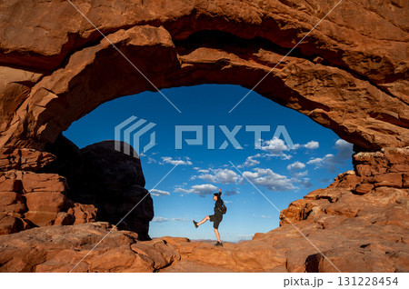Happy man tourist posing at the center of North Window in Arches National Park, Utah, USA Happy man tourist posing at the center of North Window in Arches National Park, Utah, USA 131228454