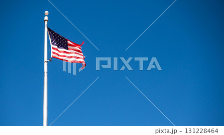 Flag of United States or American flag waving in breeze against the blue sky 131228464