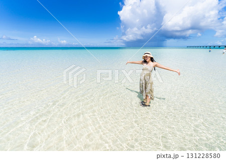 【南国リゾート】青い空とどこまでも続く美しいビーチと若い女性 【南国リゾート】青い空とどこまでも続く美しいビーチと若い女性 131228580