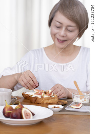 朝食のパンを食べるシニア女性 アウトフォーカス 131228784