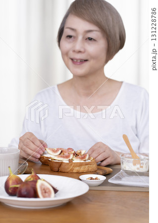 朝食のパンを食べるシニア女性 アウトフォーカス 131228786