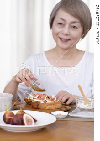 朝食のパンを食べるシニア女性 アウトフォーカス 131228792