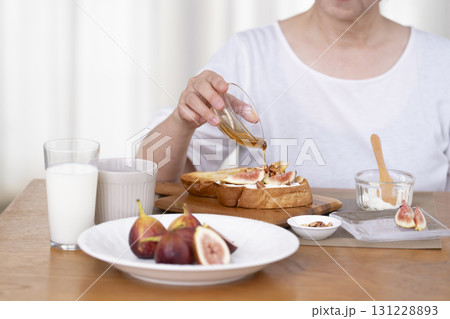 朝食のオープンサンドを作るシニア女性の手元 朝食のオープンサンドを作るシニア女性の手元 131228893